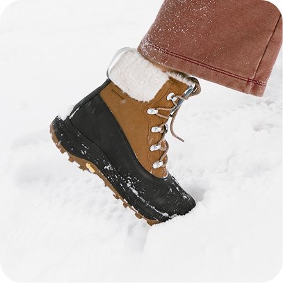 Woman stepping through deep snow wearing Merrell insulated winter boots