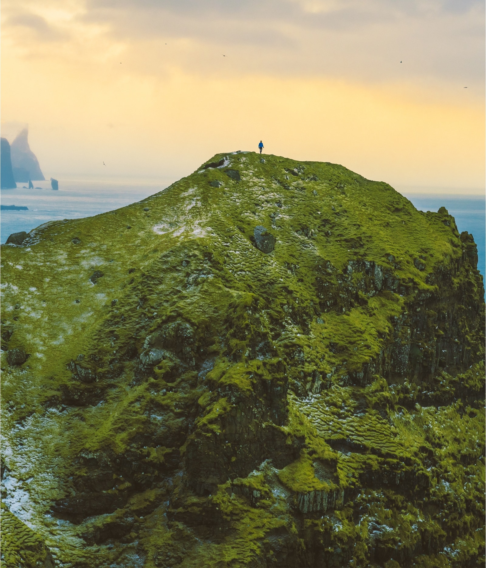 Person standing on top of a mountain.