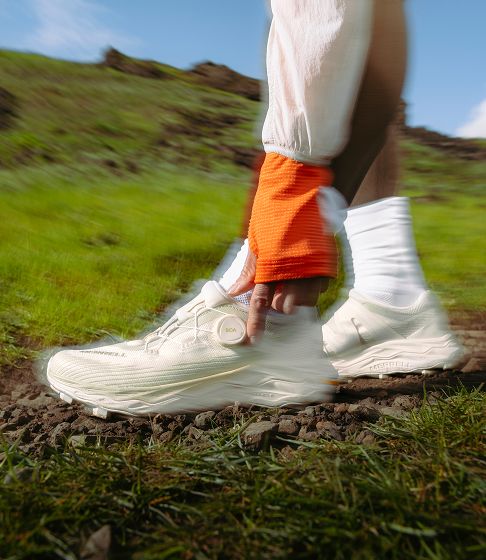 Woman walking through a grassy field.