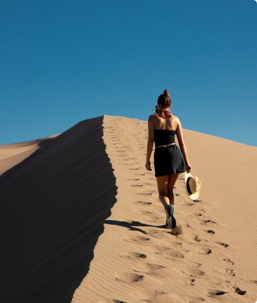 Manuela walking on a sand dune.