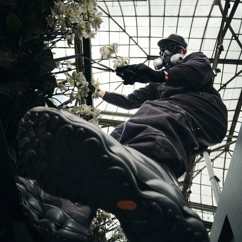Mr. Flower Fantastic climbing a greenhouse frame in Merrell shoes