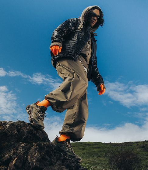 Man hiking on a grassy hillside.