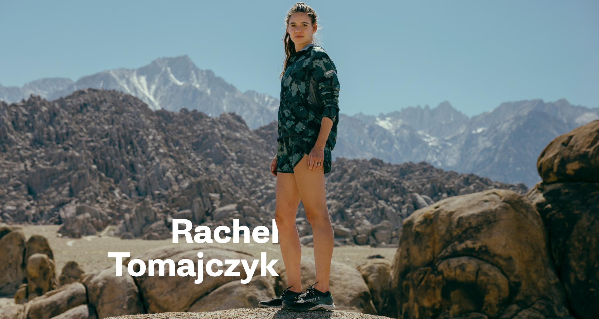 Rachel Tomajczyk standing in the mountains wearing Merrell gear, looking fast.