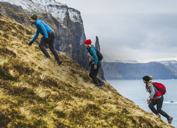 Three people hiking a mountain.