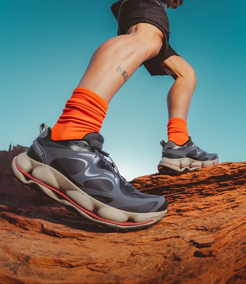 Person walking in merrell shoes outside.