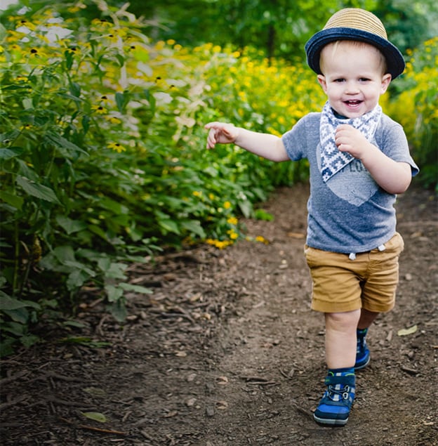 A cute baby hiking on a trail