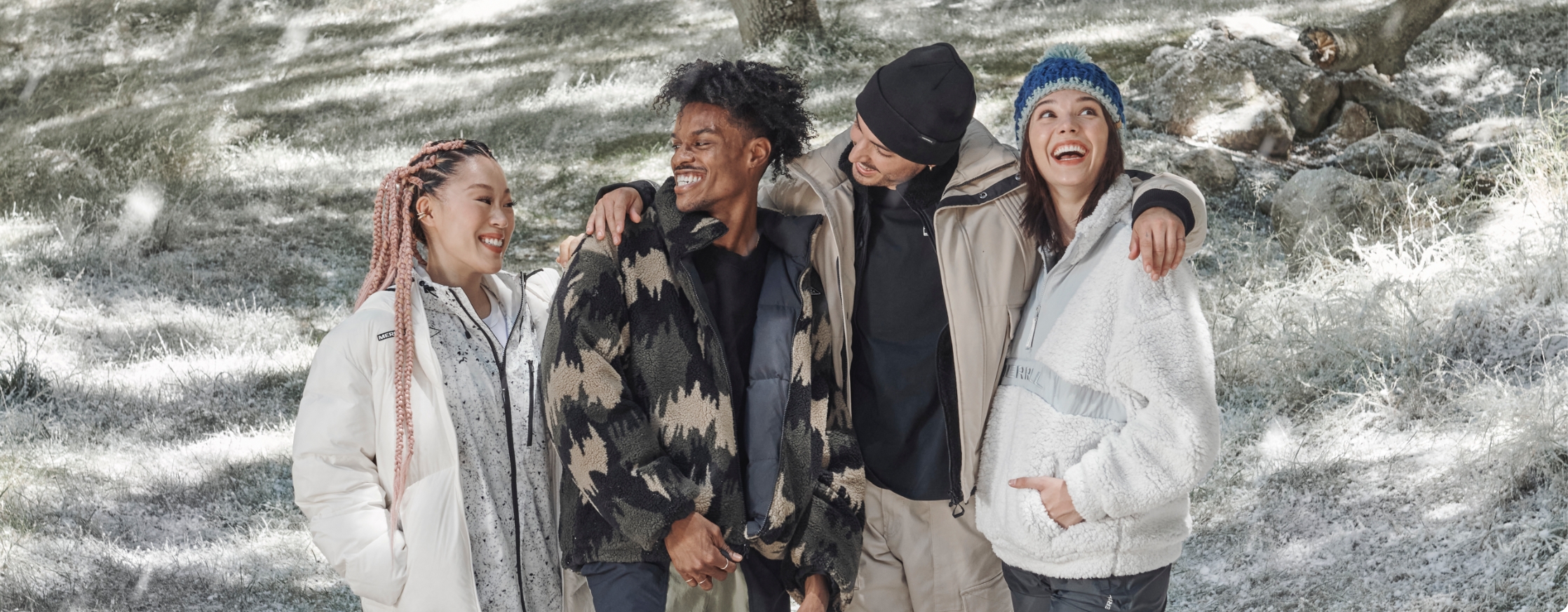 People standing happily together in the snow wearing Merrell clothes.
