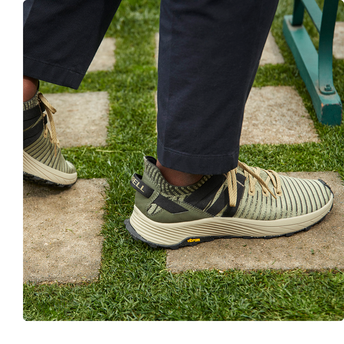 A pair embark lace sneakers sitting on the floor with a colored background.