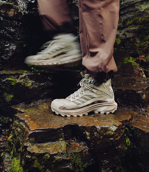 Hiker crossing wet rocks in waterproof shoes.