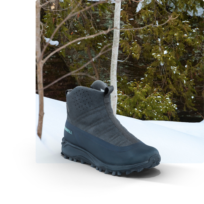 Boot on a snowy hill beside a forest.