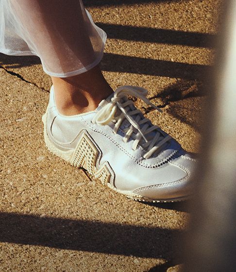 Merrell Shoes being worn by a person on concrete.