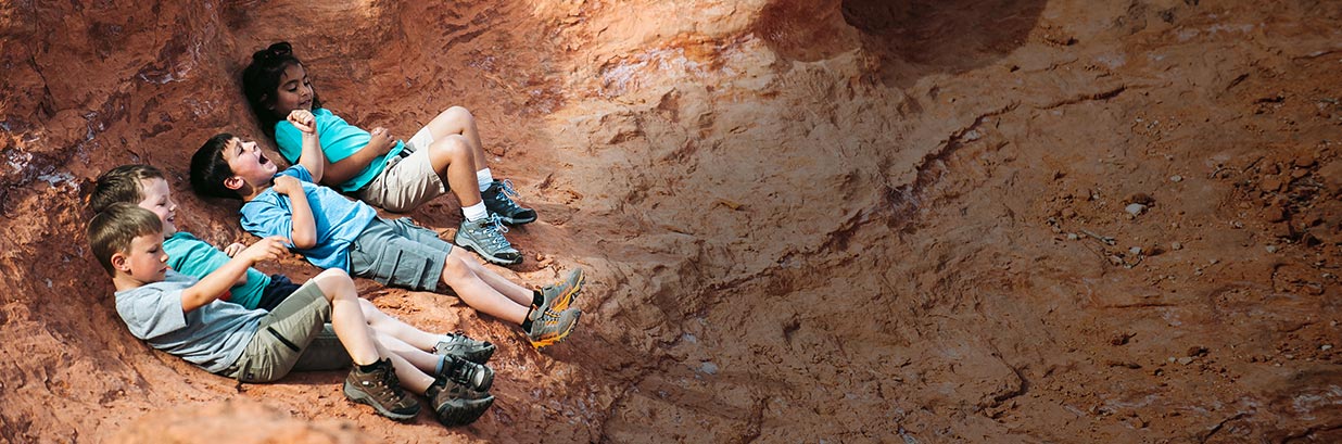 4 kids hanging out on rock formation