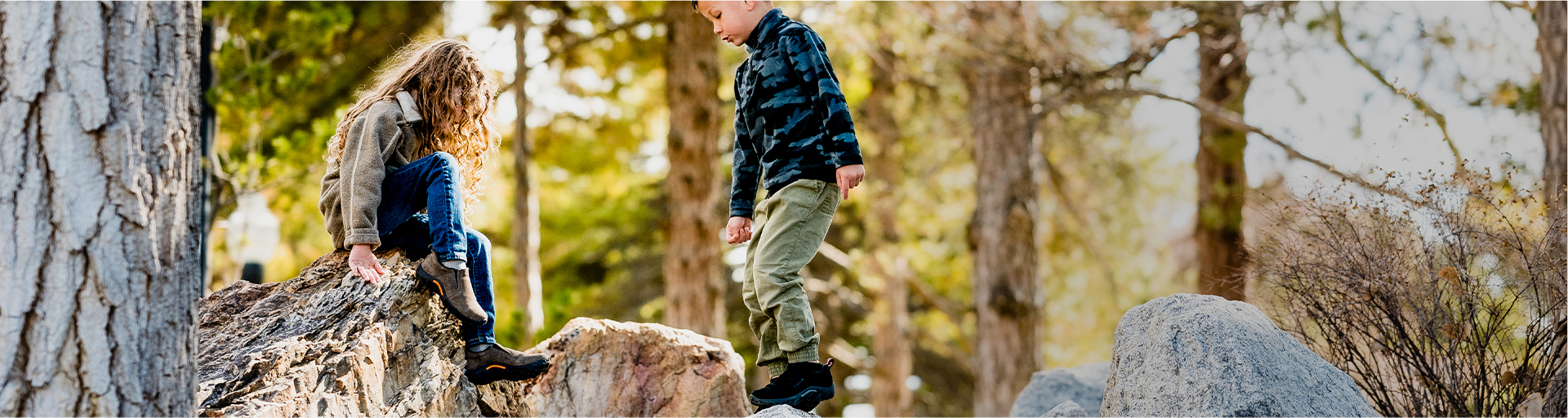 Kids playing in the woods while wearing Merrell shoes.