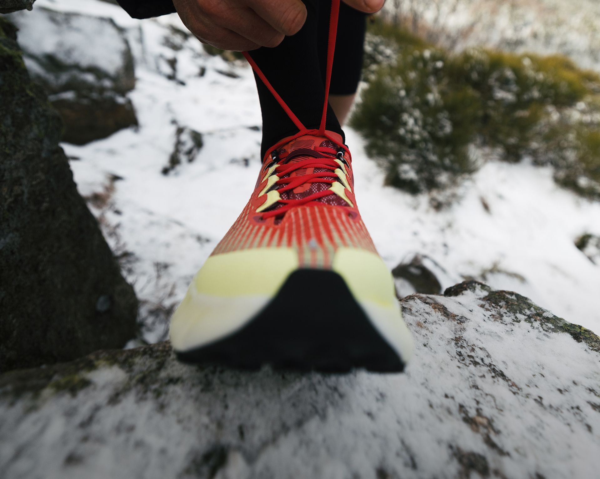 People wearing Merrell gear playing in the snow.