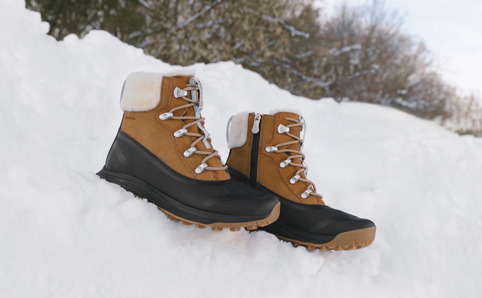 Brown Merrell Siren Thermo boots standing in the snow.