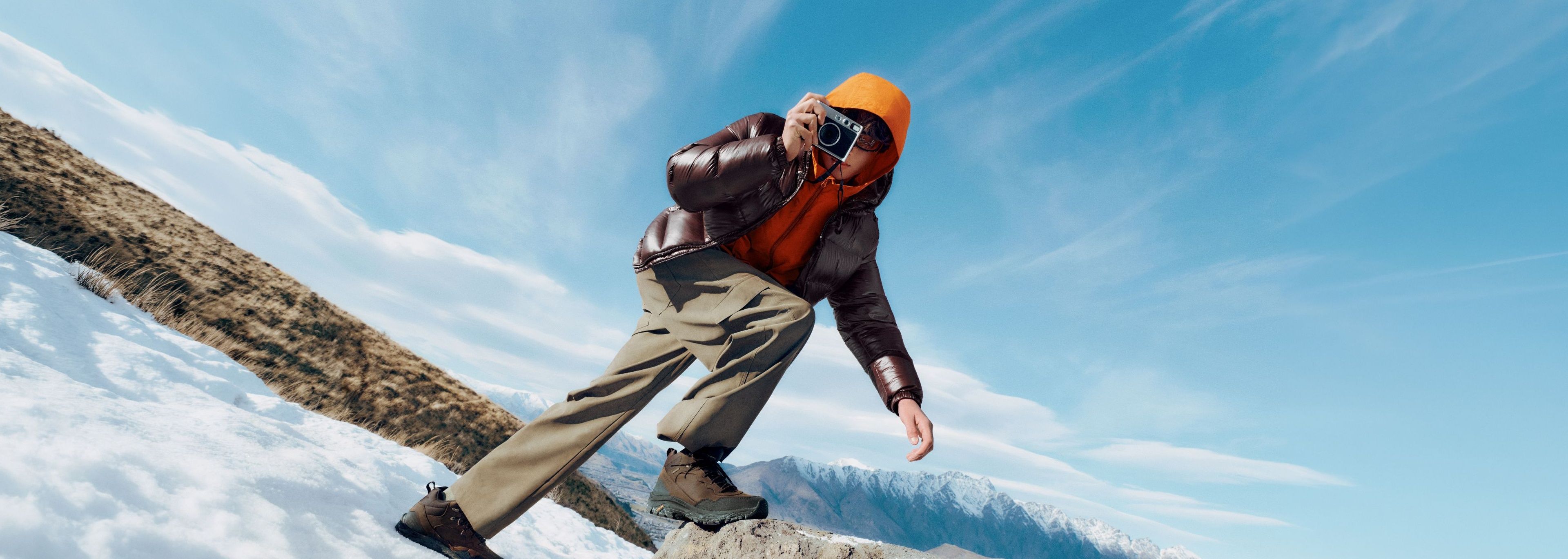 An outdoor adventurer wearing Merrell boots in a snowy mountain landscape.