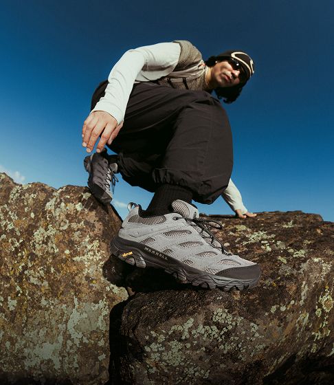 Person running outside in Merrell trail running shoes.
