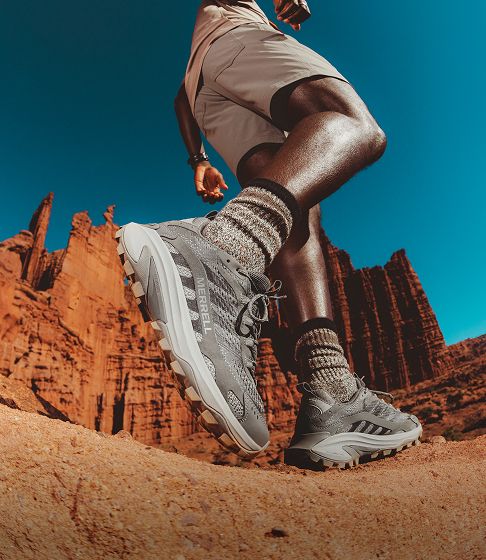 Person walking in merrell shoes outside.