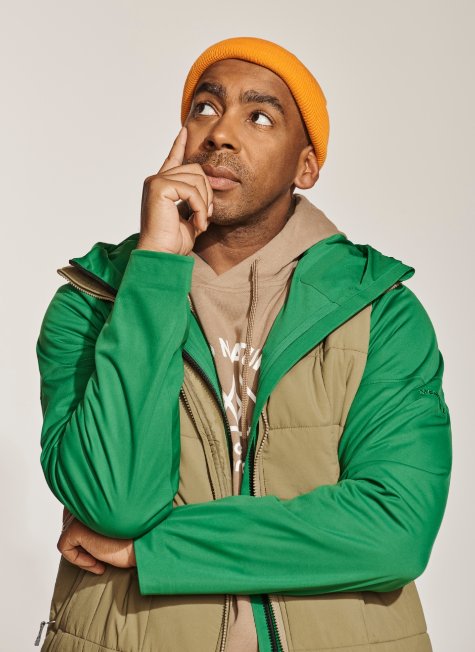 Jason Bolden wearing a green Merrell jacket coat, looking off into the distance, deep in thought.