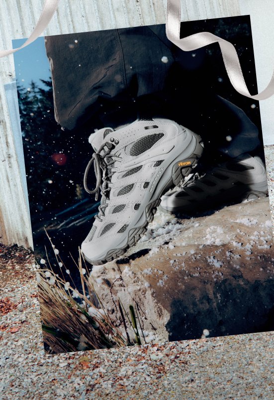 Merrell Moab 3 hiking boot stepping onto a snowy rock.