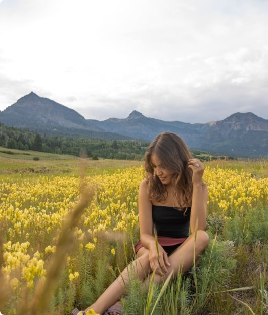 Manuela sitting in a field.