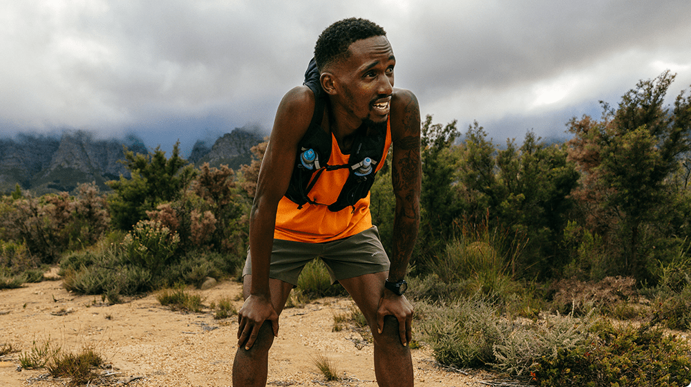 A runner looking tired after a race wearing Merrell gear.