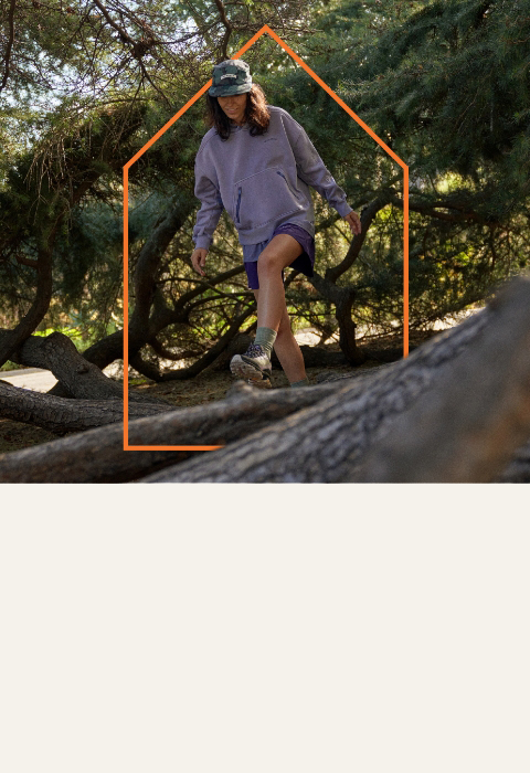 Person wearing Merrell hiking over a log