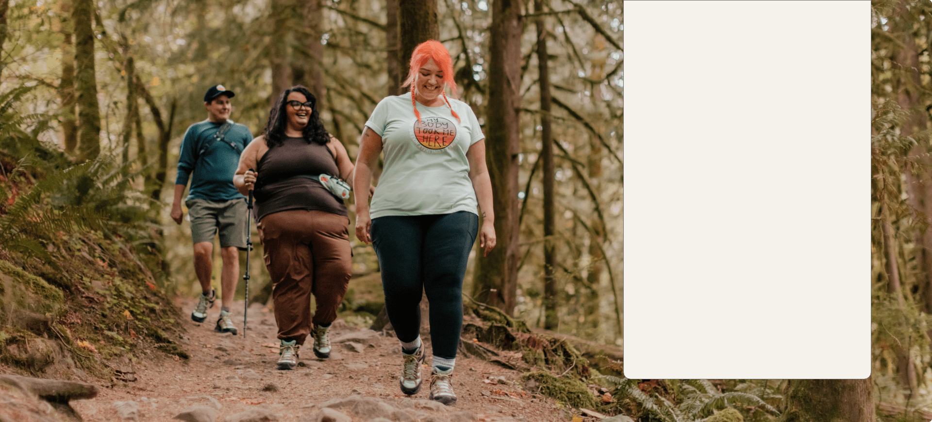 People hiking in the woods wearing Merrell gear, looking happy.