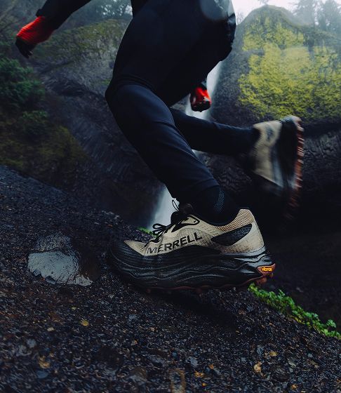 Hiker on a wet rocky trail in waterproof shoes.