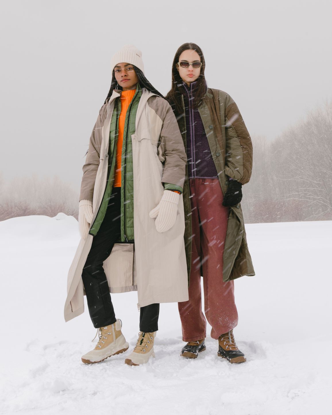 Two people wearing Merrell winter boots in a snowy landscape.