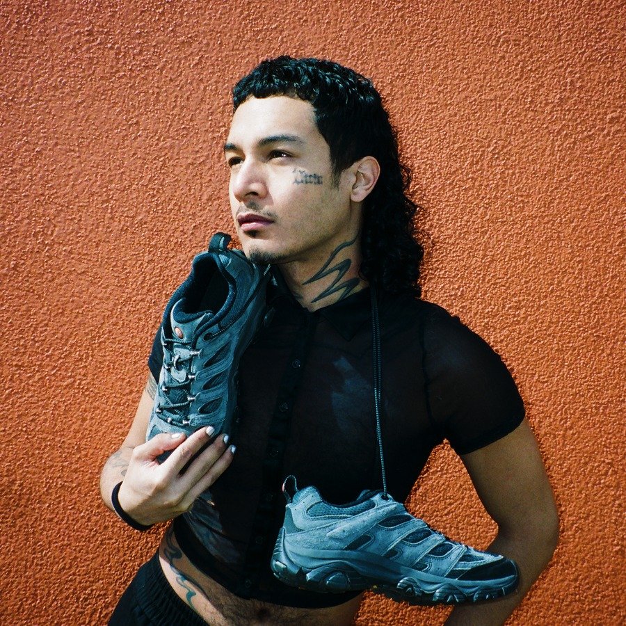Portrait of photographer Maxwell Vice holding a Merrell shoe