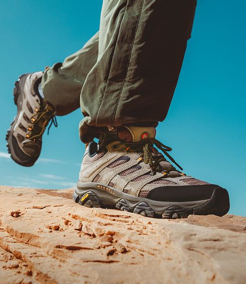 Person walking in merrell shoes outside.