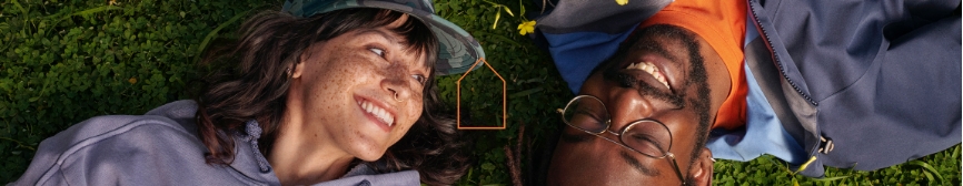 Two people laying in the grass, looking relaxed.