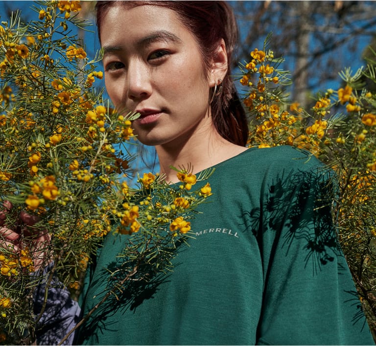 Person standing in some plants wearing a tencel shirt