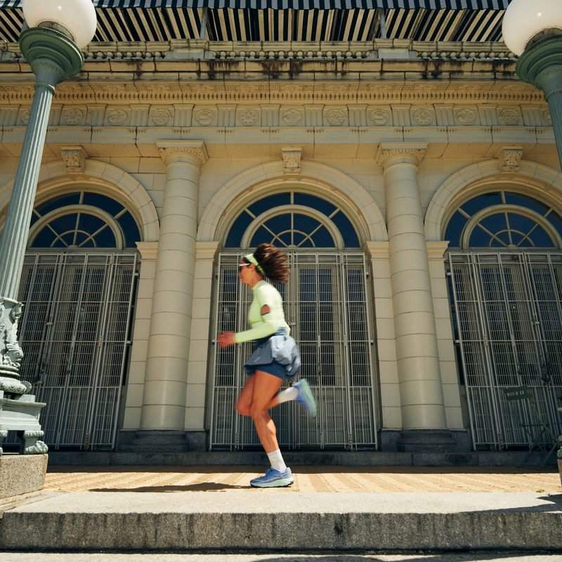 Alexi Pappas running past a columned New York City building