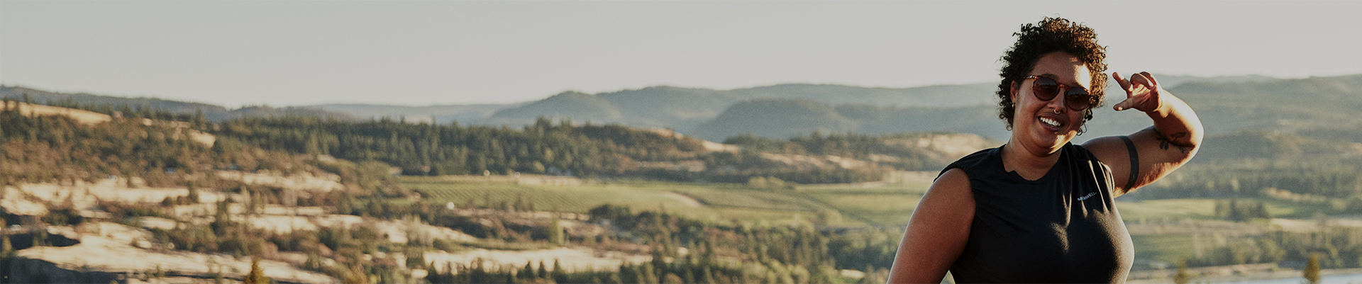 woman on a grassy hillside smiling