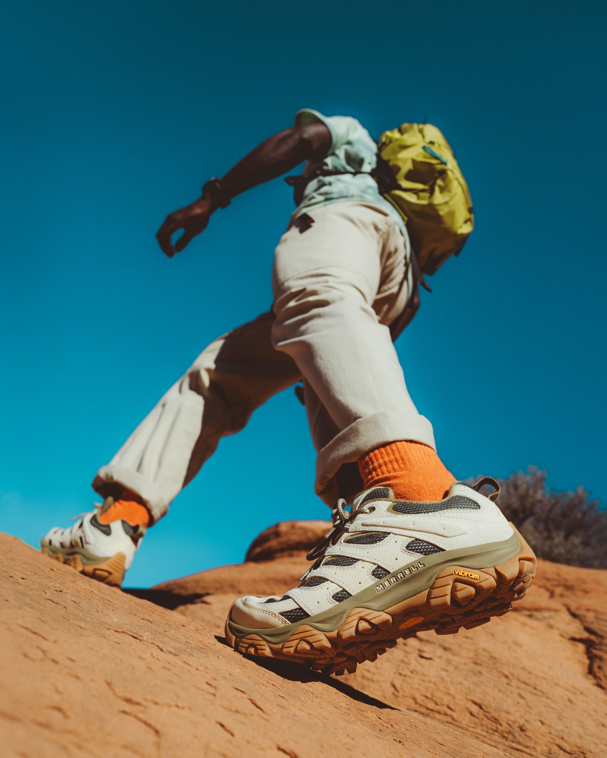 A person hiking in the desert wearing Merrell shoes.