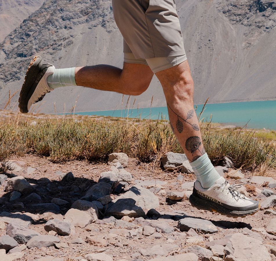 Closeup of person running on trails in Merrell Agility Peak 5 shoes