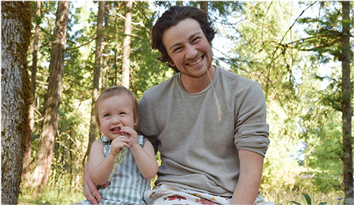 Benson Stewart, arm around his son in a forest.