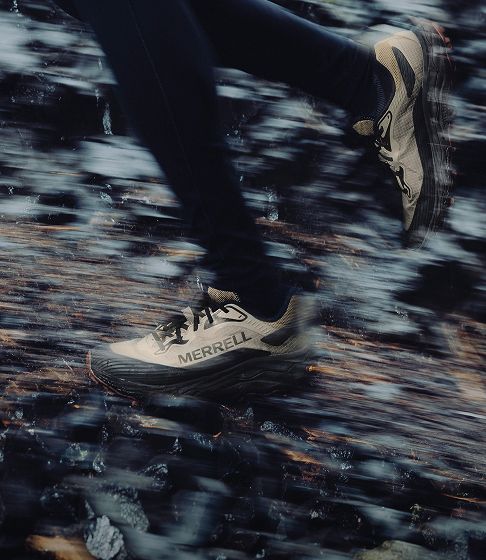 Runner splashing through water on a trail.