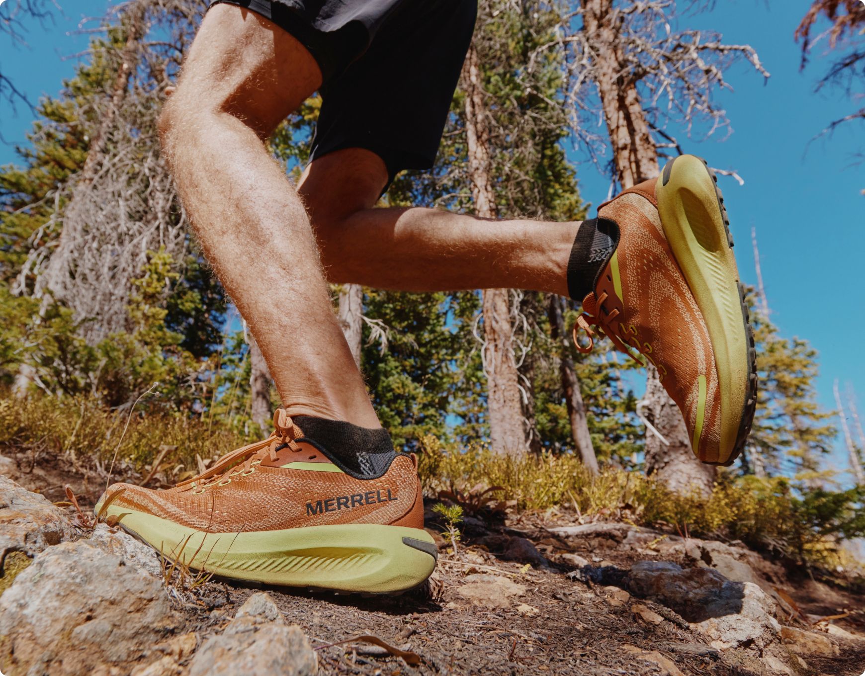 Close up of person running on the trail in Merrell shoes.