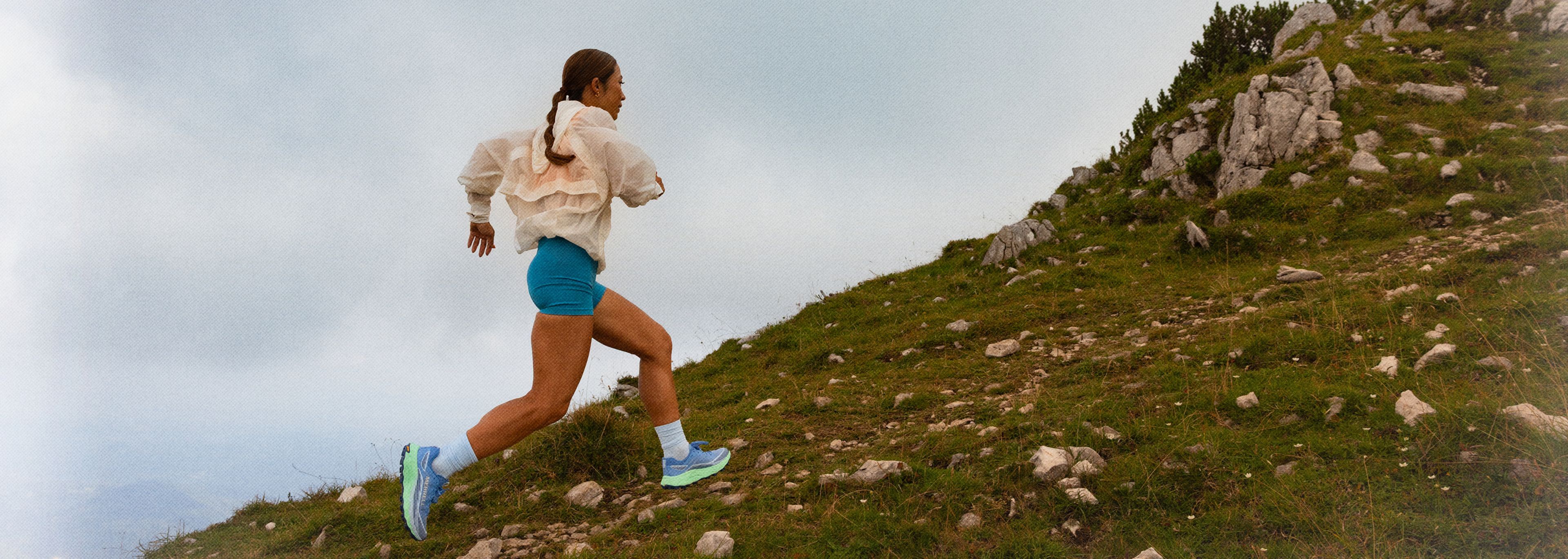 A person running on a trail wearing Merrell shoes