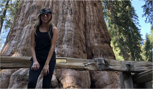 Tiffany Moreno smiling in front of a giant tree.