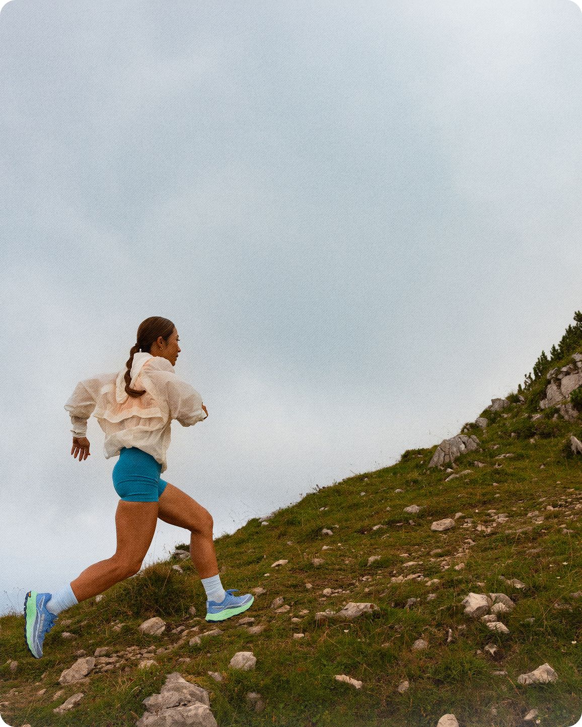 A person running on a trail wearing Merrell shoes