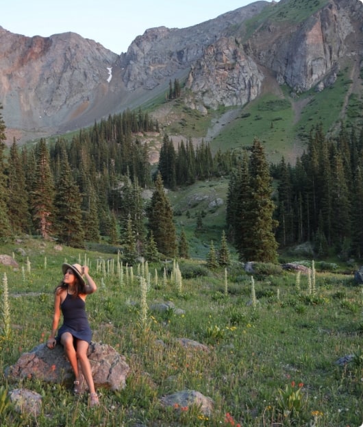 Manuela sitting in an alpine field.