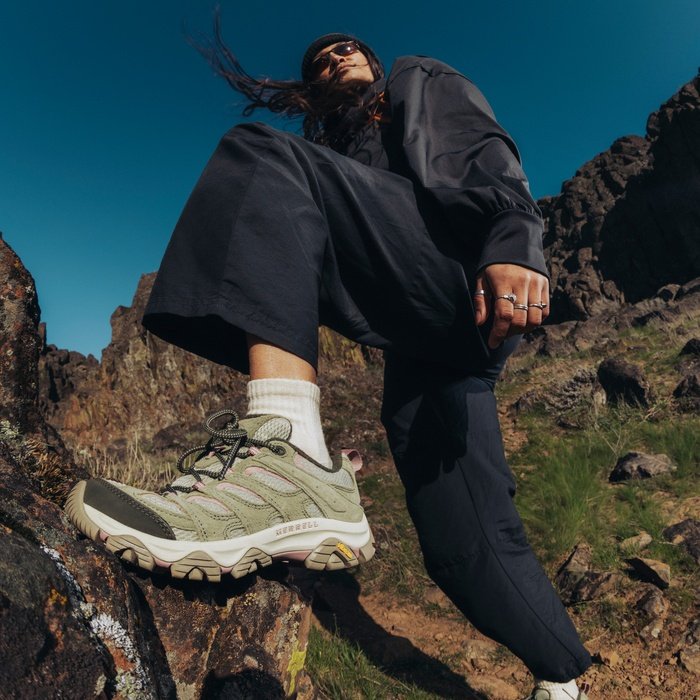 Woman standing on a rocky trail wearing Merrell Moab 3 hiking shoes